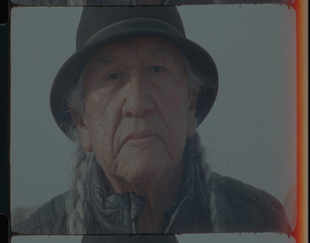 A Native American man wearing a black brimmed hat.