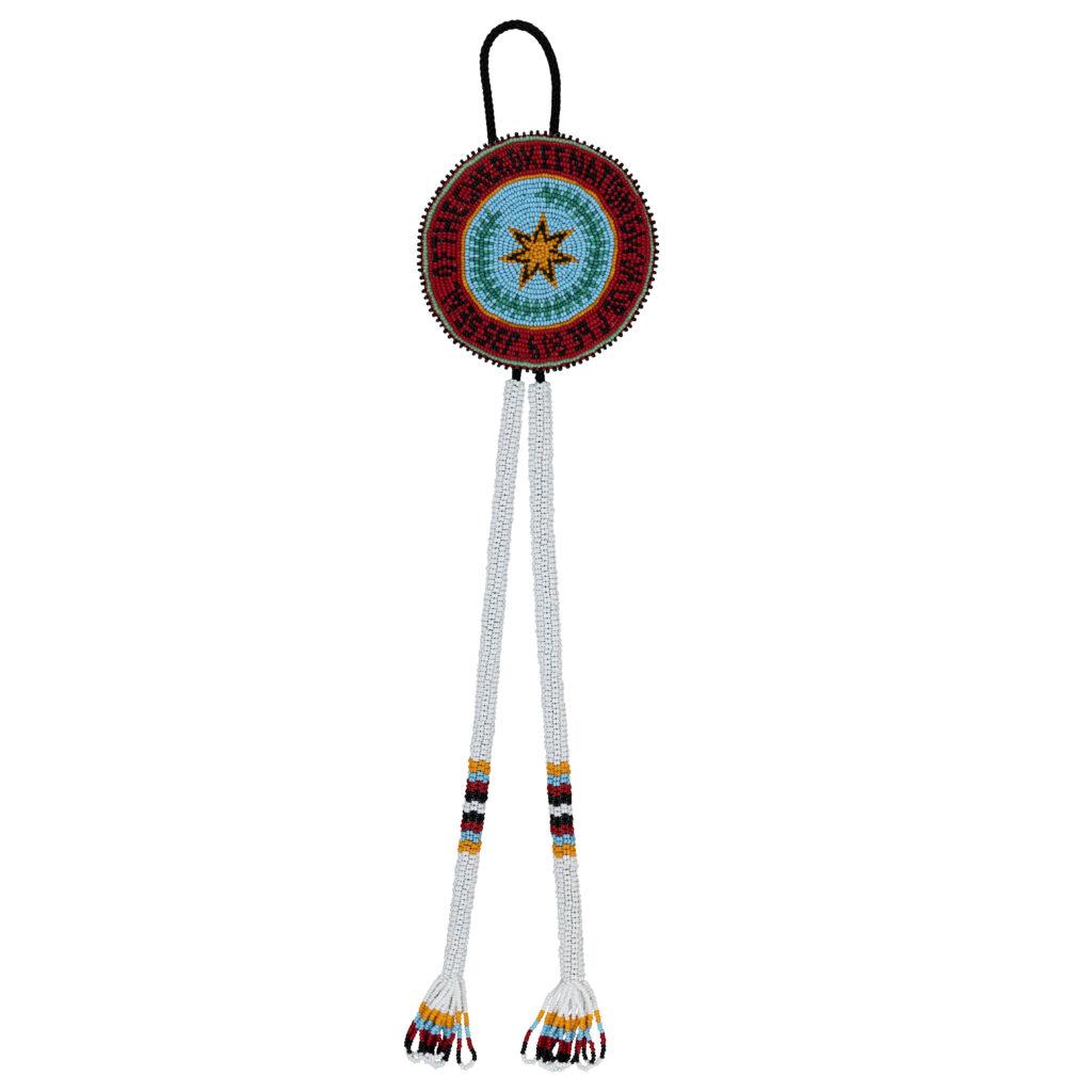 Bolo tie, attributed to Frances Crowe (Eastern Band of Cherokee Indians) n.d. Beads, thread, cordage. Museum of the Cherokee People. This beaded bolo tie, attributed to Frances Crowe (Eastern Band of Cherokee Indians), depicts the Eastern Band of Cherokee Indians tribal seal. (Courtesy Museum of the Cherokee People)
